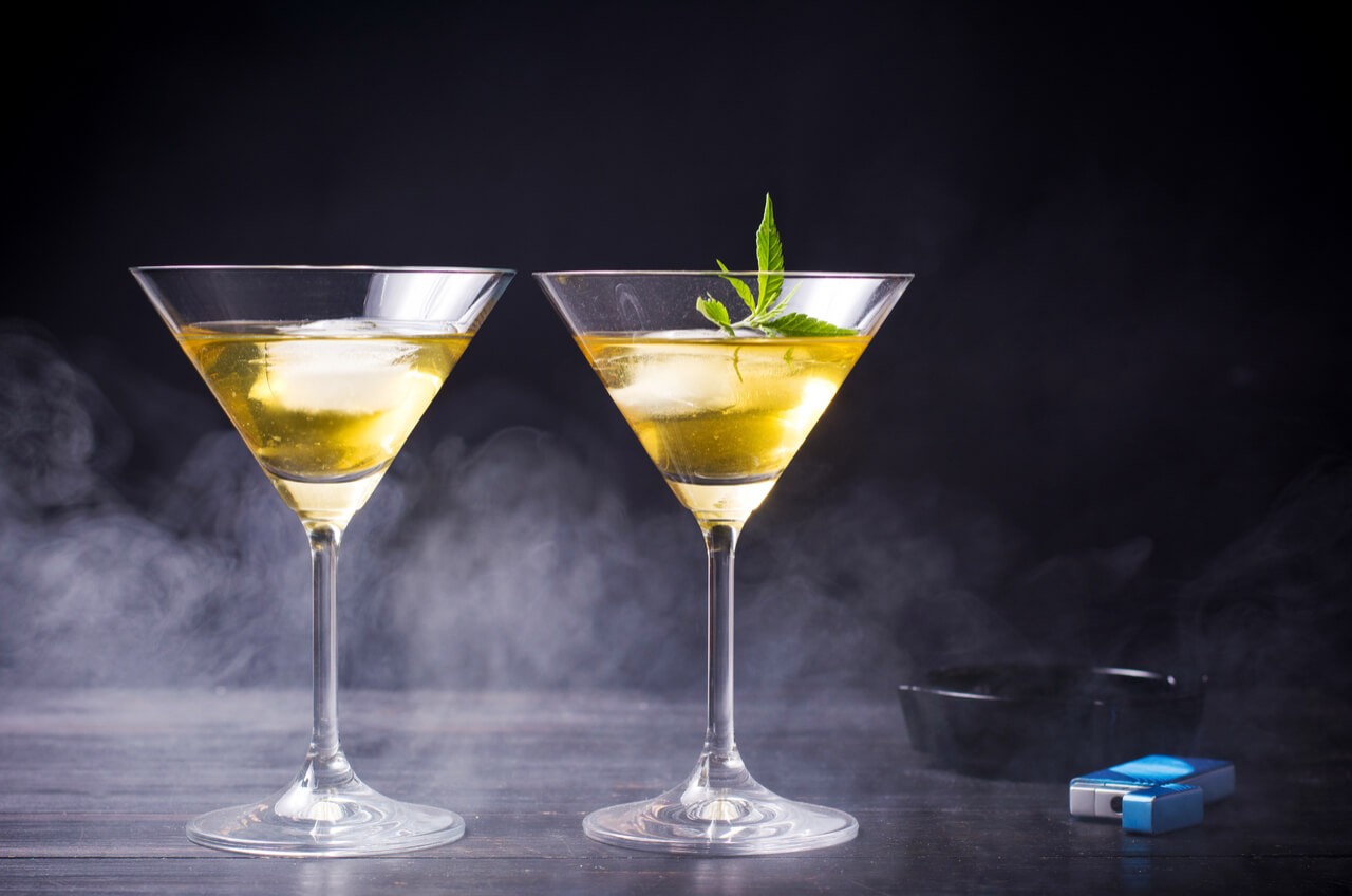 martinis and a marijuana leaf on black background