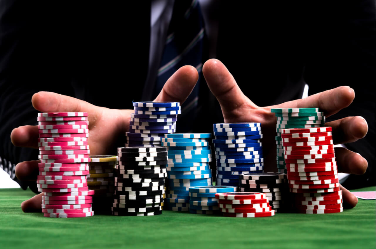 hands pushing multi-colored poker chips